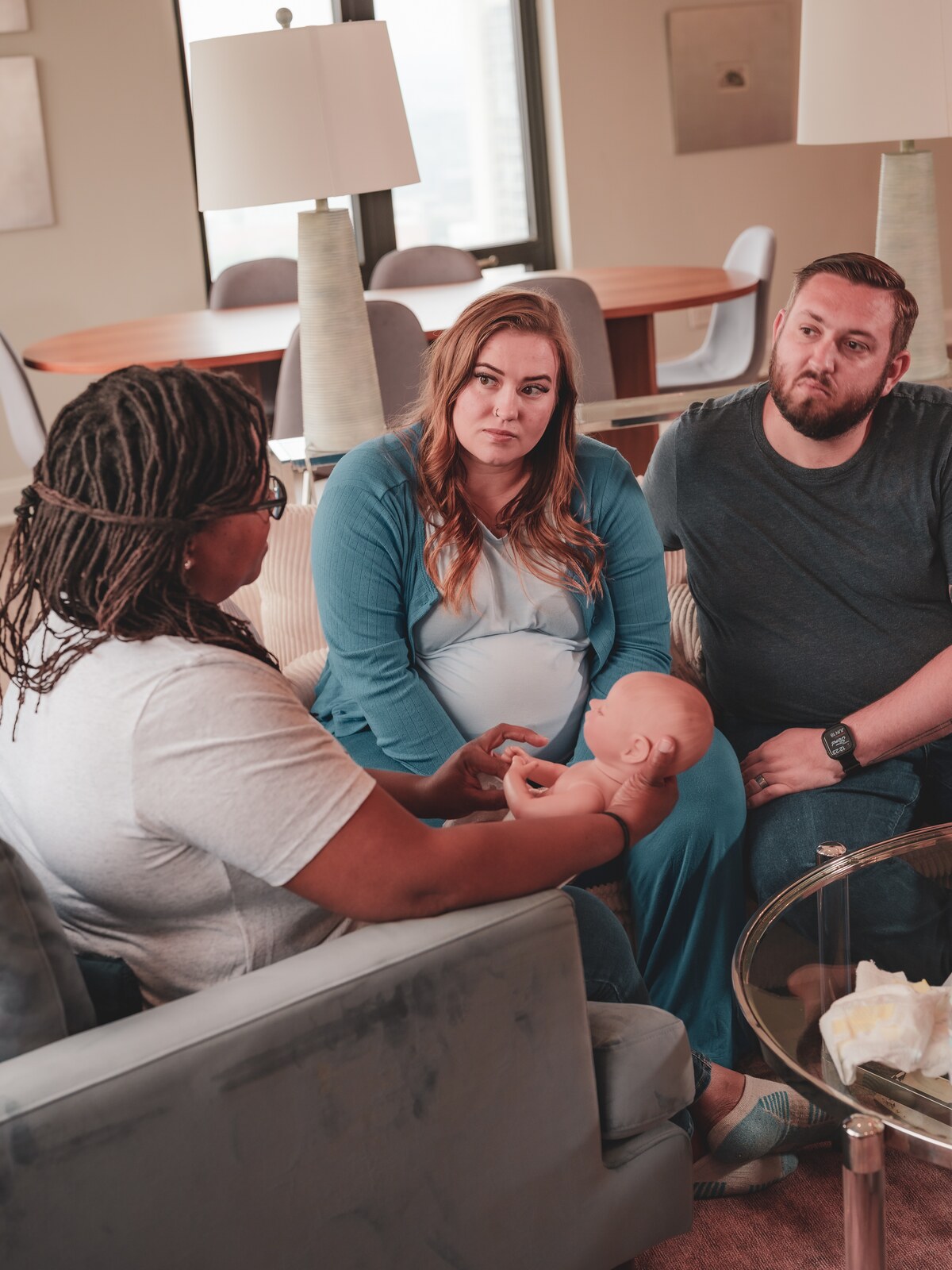 Doula teaching expecting parents about newborn care